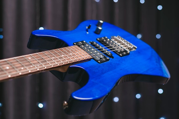 Immagine del primo piano di una chitarra elettrica blu. Tecnica mista