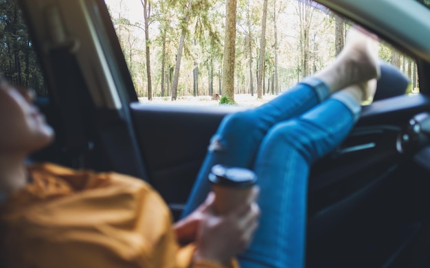 Immagine del primo piano di una donna che posa e che beve caffè in macchina