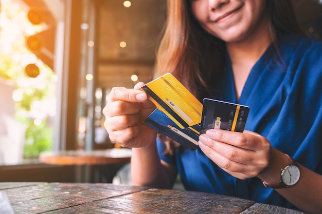 Immagine del primo piano di una donna che tiene e sceglie la carta di credito da usare