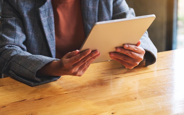 Immagine del primo piano di una donna che tiene e utilizza la tavoletta digitale