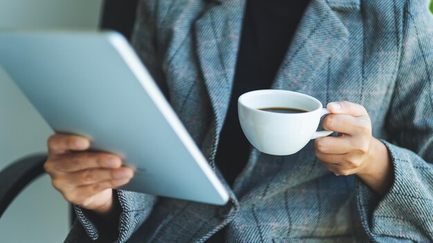 Immagine del primo piano di una donna d'affari che utilizza la tavoletta digitale in ufficio