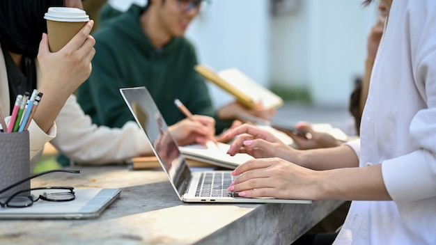 Immagine del primo piano di una studentessa universitaria che lavora a un progetto scolastico con i suoi amici