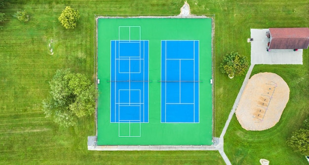 Immagine dell'antenna dritta di un campo da tennis incontaminato con un'altalena vicina per il parco giochi