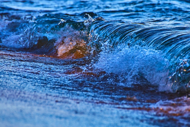 Immagine dell'onda increspata che si rompe durante un temporale in profondi blu e viola