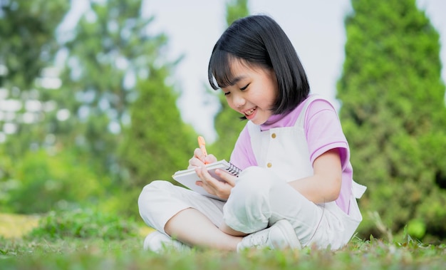 Immagine della bambina asiatica che studia al parco