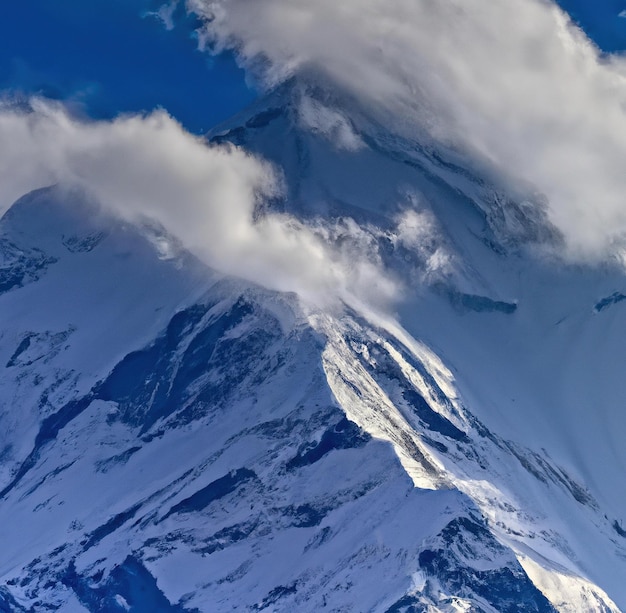 Immagine della catena rocciosa delle montagne himalayane con nuvole e cime innevate