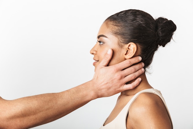 Immagine della donna africana in posa mentre la mano di qualcuno tocca il suo collo.