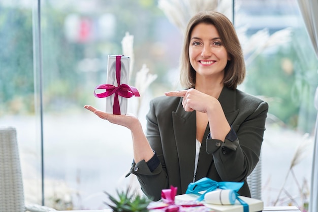 Immagine della donna che tiene un regalo nel ristorante