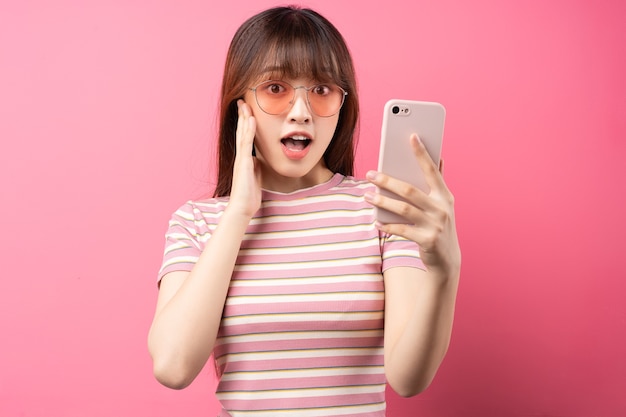 Immagine della giovane ragazza asiatica che indossa la maglietta rosa sul rosa