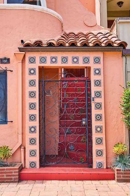 Immagine della porta d'ingresso di una casa moderna rosa a San Francisco con cancello e gradini rossi