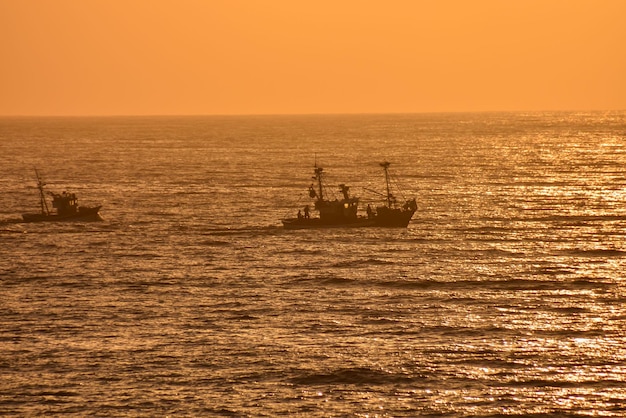 Immagine della retroilluminazione di una barca della siluetta nell'oceano