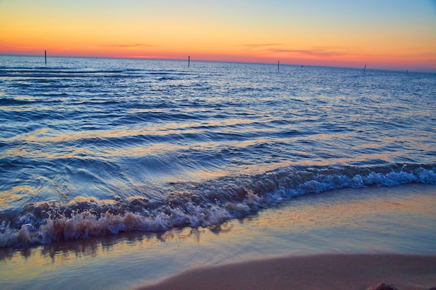 Immagine della spiaggia sul lago con onde d'acqua e colori del tramonto all'orizzonte