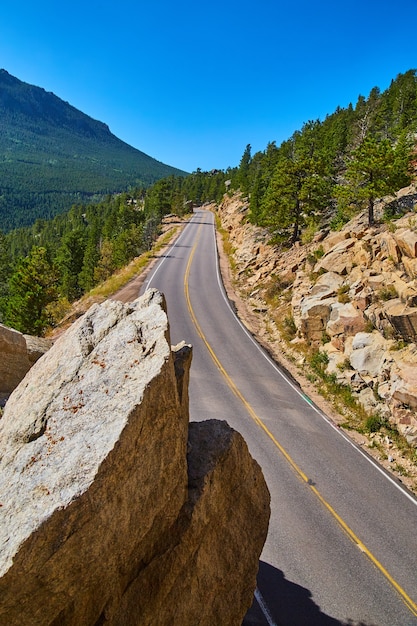 Immagine della strada verticale che attraversa le montagne accanto a grandi massi