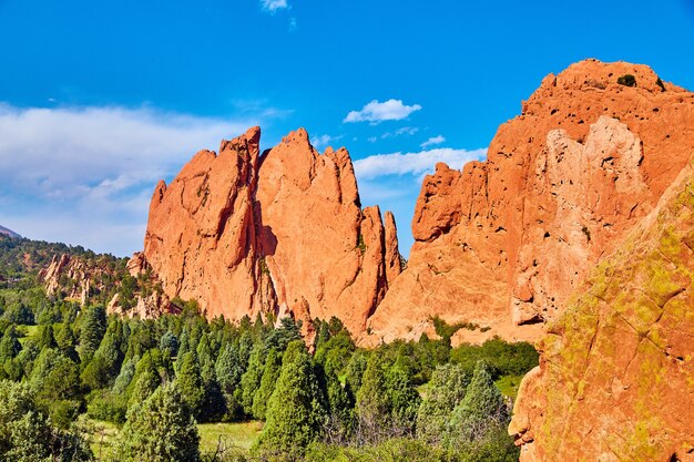 Immagine di affioramenti giganti di rocce rosse in montagne e foreste verdi