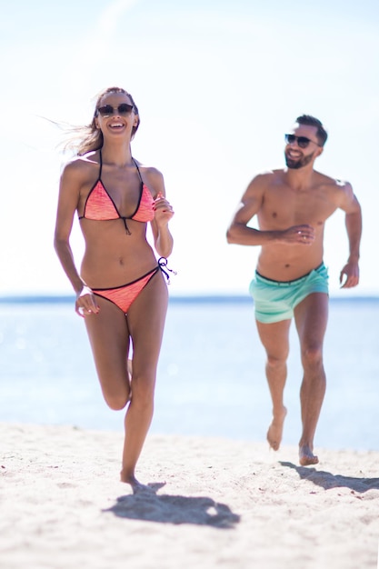 Immagine di amanti felici che corrono sulla spiaggia