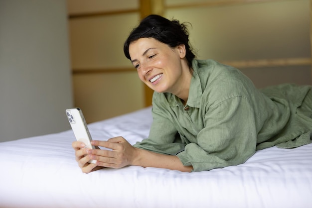 Immagine di donna allegra in casa sorridente al telefono