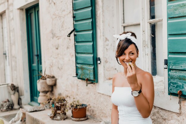 Immagine di moda all&#39;aperto di bella giovane donna bruna elegante mangiare fico