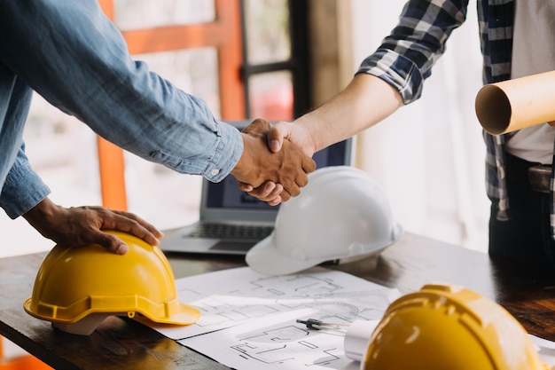 Immagine di oggetti di ingegneria sul posto di lavoro con tre partner che interagiscono sullo sfondo