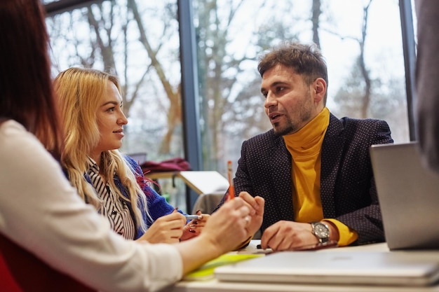 Immagine di partner commerciali che discutono di documenti e idee durante la riunione