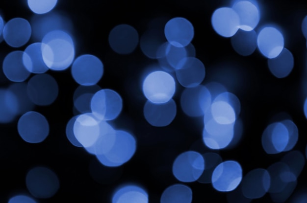 Immagine di sfondo astratta con effetto bokeh Molte forme circolari dai colori vivaci su uno sfondo scuro fantasma classico colore blu