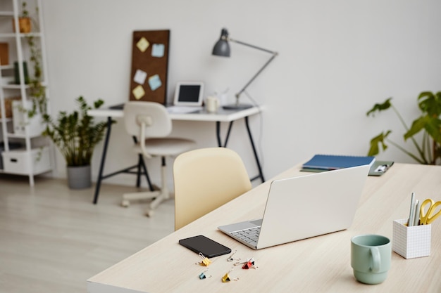 Immagine di sfondo del laptop aperto sulla scrivania in un comodo interno dell'ufficio senza persone