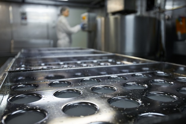 Immagine di sfondo del nastro trasportatore industriale in una fabbrica di produzione alimentare pulita con una lavoratrice irriconoscibile, spazio di copia