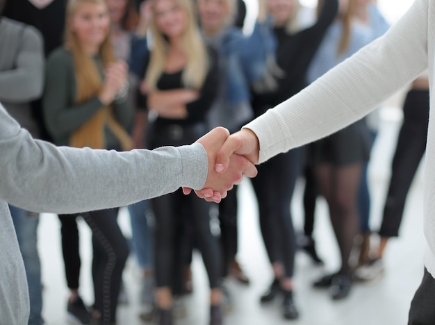 Immagine di sfondo di diversi giovani che si stringono la mano