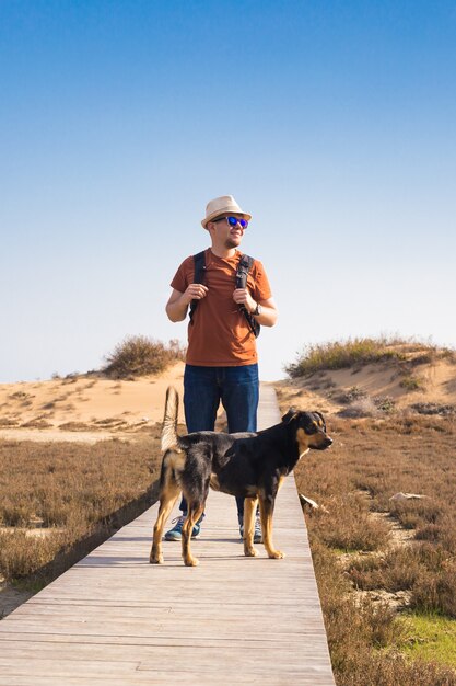 Immagine di stile di vita all'aperto dell'uomo in viaggio con un cane carino. Concetto di turismo.