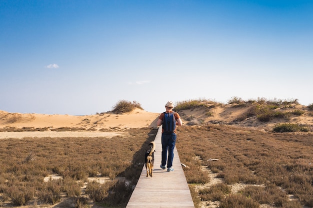 Immagine di stile di vita all'aperto dell'uomo in viaggio con un cane carino. Concetto di turismo.