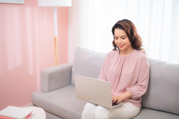 Immagine di stile di vita della giovane donna asiatica utilizzando il computer portatile