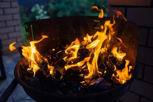 Immagine di stock di carbone di legna grill, close up con fiamme vive.