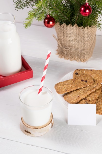 Immagine di tradizione natalizia Latte per biscotti di Babbo Natale rami di abete su tavola bianca