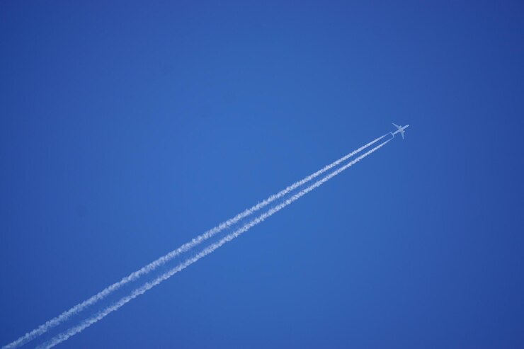 Foto immagine di un aereo con tracce di condensazione in un cielo blu