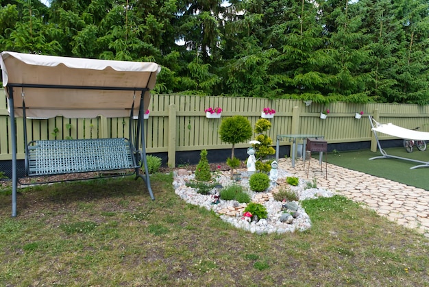 Immagine di un bel cortile nella propria casa in estate Alberi di fiori e statuette con un design accogliente