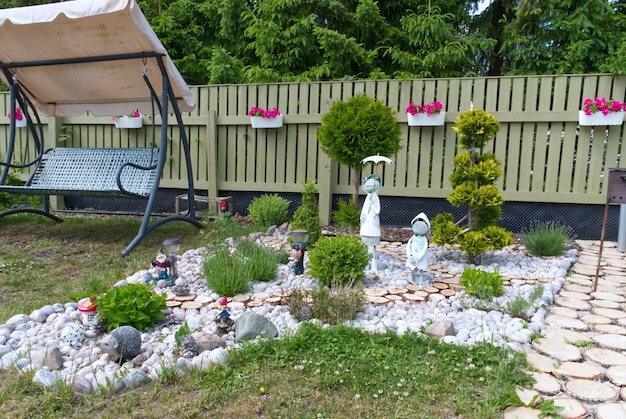 Immagine di un bel cortile nella propria casa in estate Fiori di alberi e statuette con un design accogliente