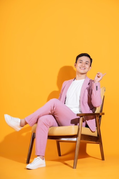 Immagine di un giovane asiatico seduto su una sedia
