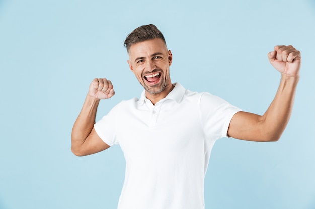 Immagine di un uomo adulto emotivo emozionante bello che posa sopra la danza blu della parete.