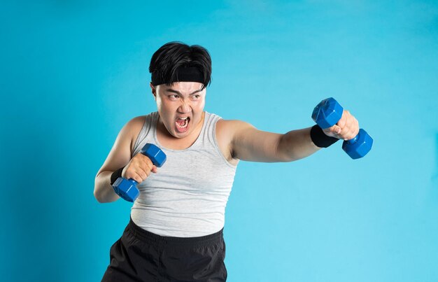 Immagine di un uomo asiatico che si esercita su uno sfondo blu