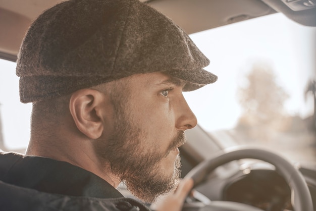 Immagine di un uomo elegante alla guida di un'auto in una giornata di sole. concetto di taxi. Tecnica mista