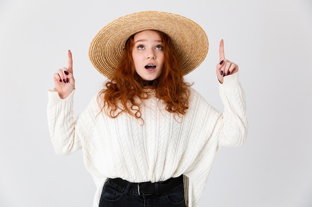 Immagine di una bella rossa scioccata giovane ragazza carina in posa isolato su sfondo bianco muro che indossa il cappello.