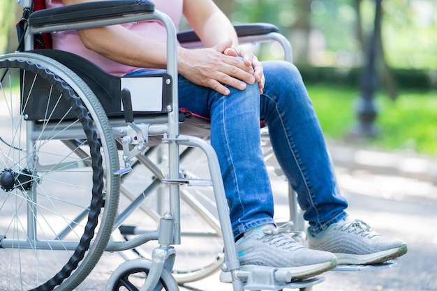 Immagine di una donna asiatica di mezza età seduta su una sedia a rotelle