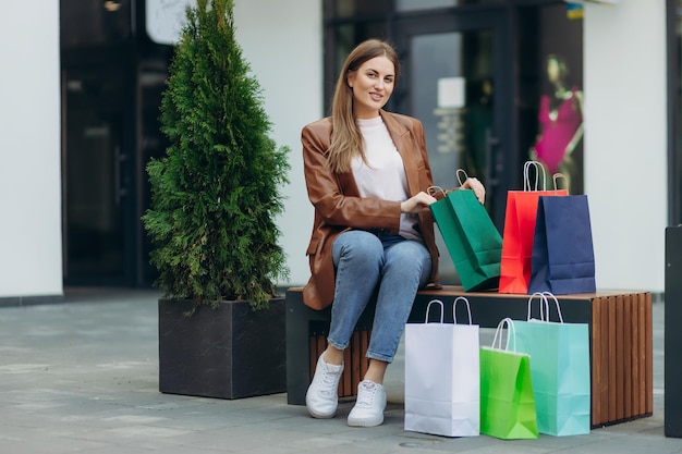 Immagine di una donna che apre e guarda una borsa della spesa per strada per la consegna e il concetto di shopping online