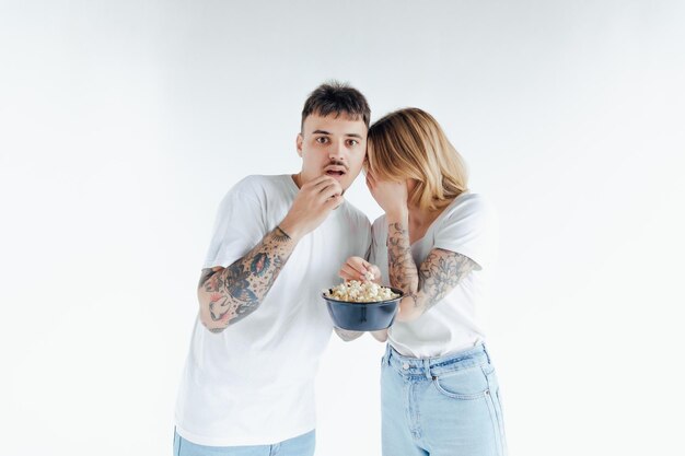 Immagine di una famiglia ansiosa a casa che ti guarda mentre guarda un film spaventoso e mangia popcorn