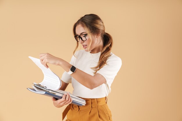 Immagine di una giovane donna d'affari che indossa occhiali che tiene appunti e libri del registro isolati
