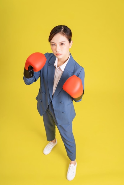 Immagine di una giovane imprenditrice asiatica con guantoni da boxe