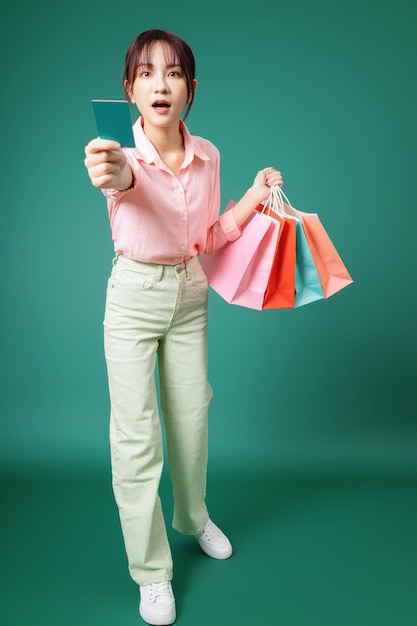 Immagine di una giovane ragazza asiatica che tiene la borsa della spesa sullo sfondo