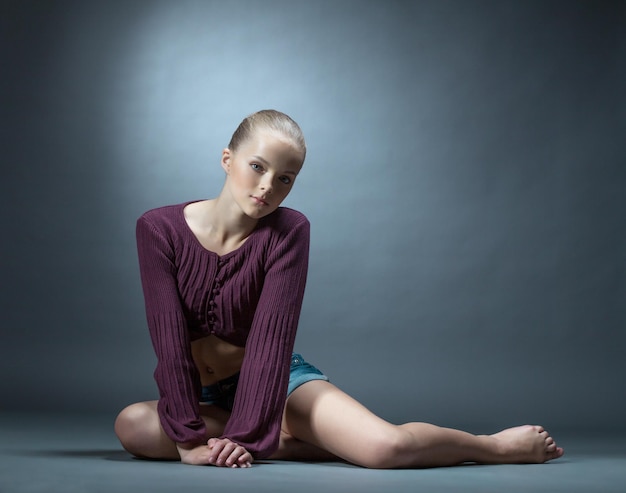 Immagine di una ragazza vestita alla moda che posa in studio