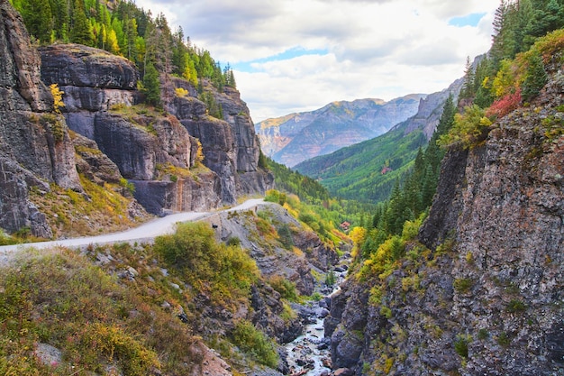 Immagine di una strada sterrata pericolosa in montagna vicino al bordo con gola e grandi scogliere