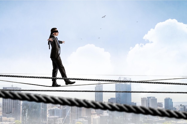 Immagine di uomo d'affari in equilibrio sulla corda. Concetto di rischio. Tecnica mista