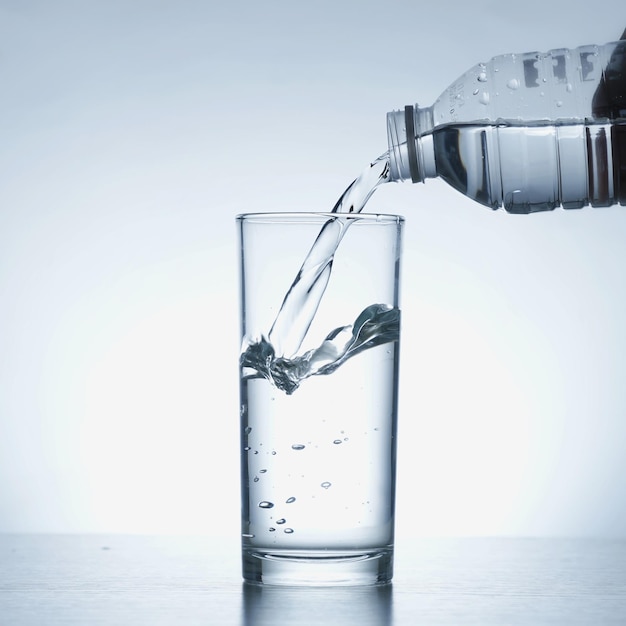 Immagine di versare acqua da una bottiglia d'acqua in un bicchiere